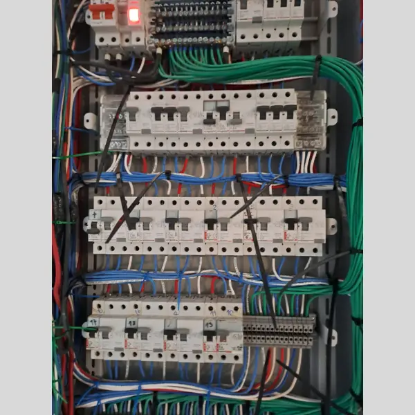 Interior de tablero eléctrico industrial con breakers organizados, cableado de colores según normativa y borneras de distribución — instalación certificable SEC