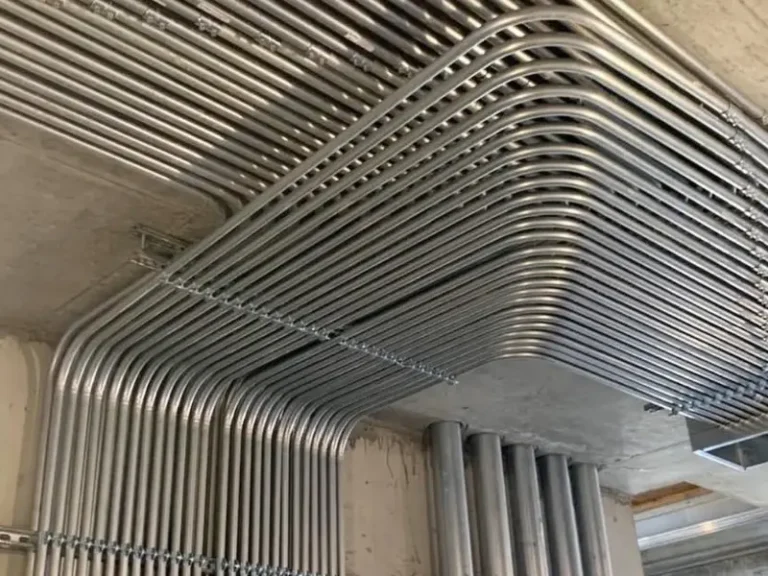 Canalizaciones EMT galvanizadas alineadas en techo de hormigón — instalación eléctrica industrial certificable TE1 en Pudahuel.