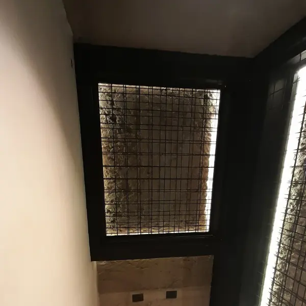 Detalle de instalación de retroiluminación LED para muro de piedra en cava.