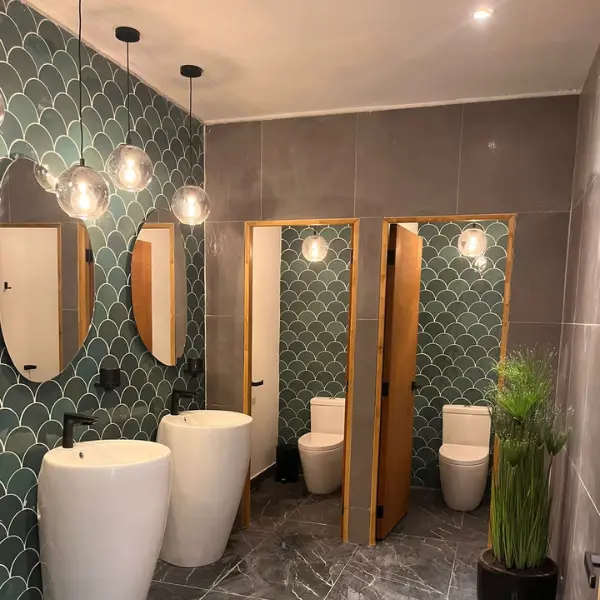 Instalación eléctrica en baños comerciales con lámparas tipo globo y sistema de iluminación eficiente