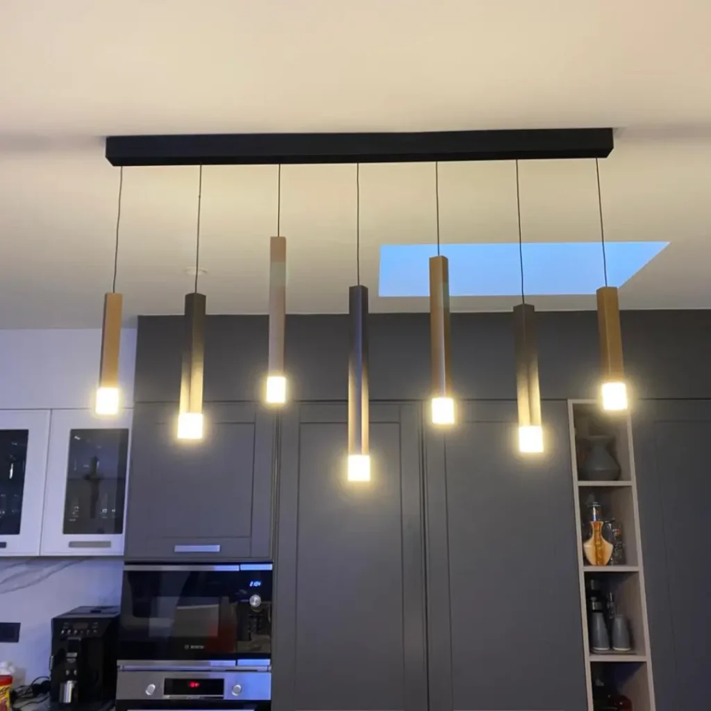 Instalación de lámparas colgantes decorativas en cocina moderna realizada en proyecto eléctrico residencial en Lo Barnechea